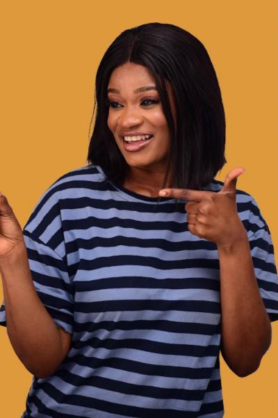 A smiling young woman pointing at her phone